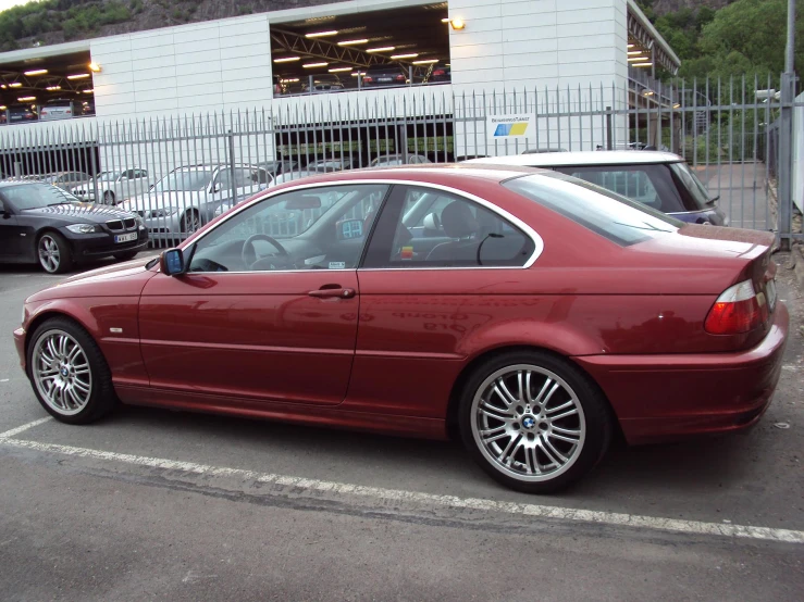 a red bmw sedan parked in a parking lot