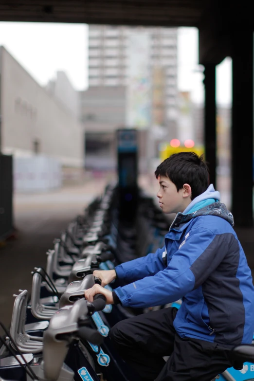 a  riding a bicycle next to a long row of bikes