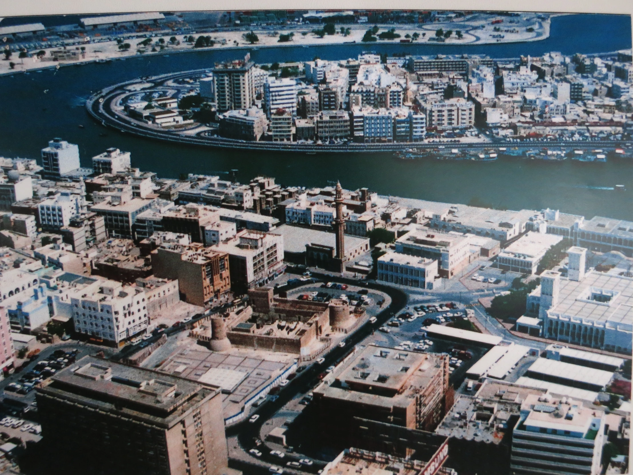 a city with many tall buildings in front of a river