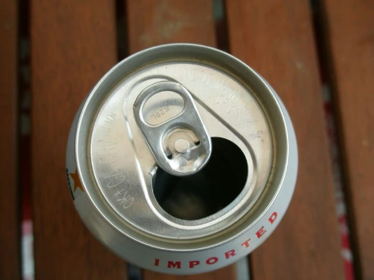 an empty can sitting on top of a wooden bench