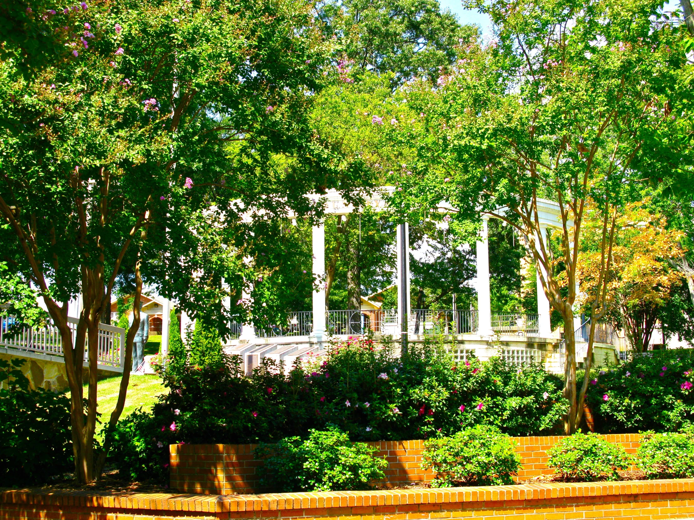 a wall and some green trees and bushes