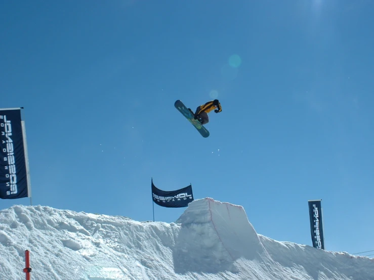 a snowboarder is in the air above a snowy hill