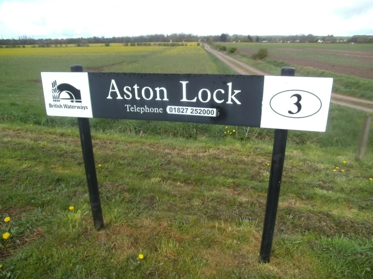a black and white sign on a grass field