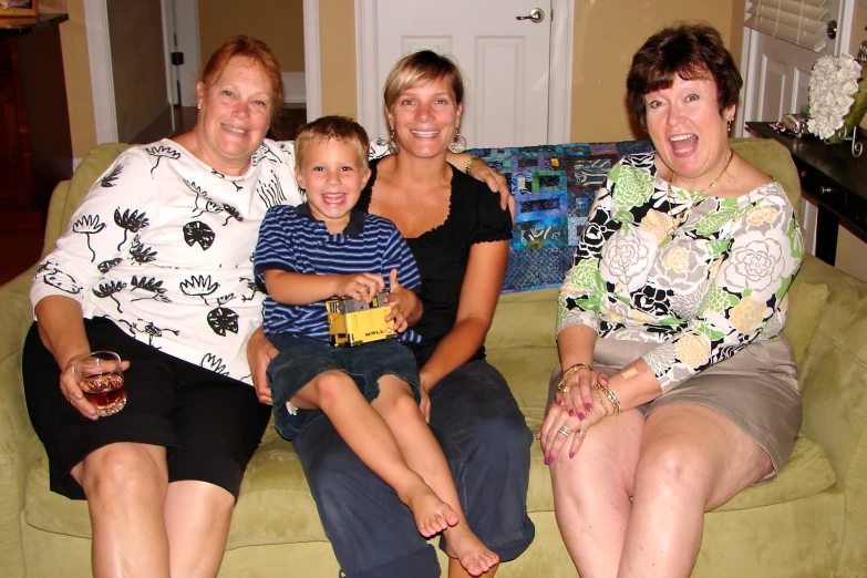 two woman and two children sitting on the couch