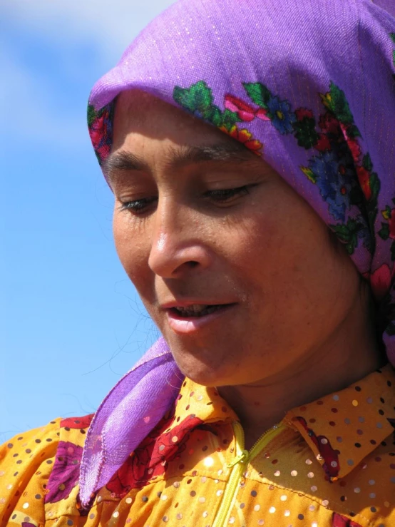 woman in brightly colored clothing with bright purple scarf