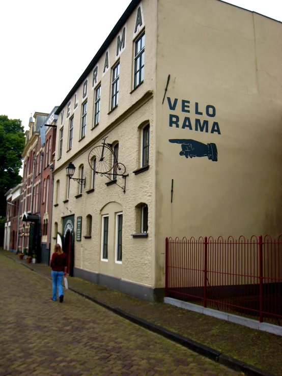 a lady walks in front of a building called velo ramma