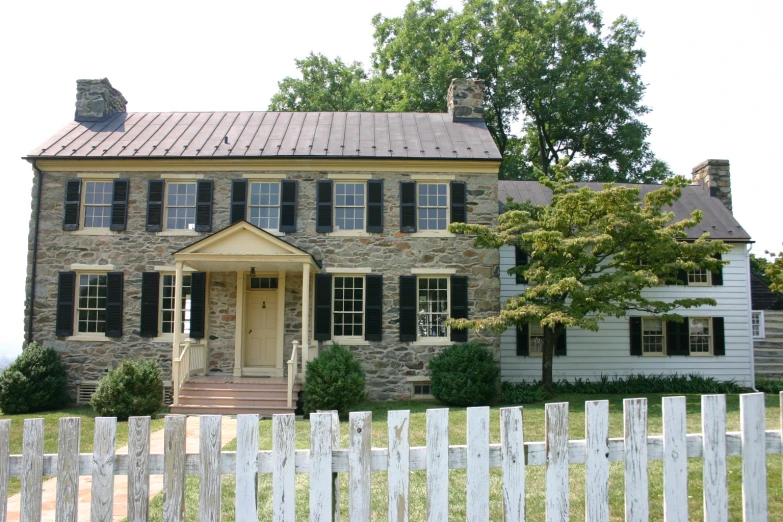 a very cute stone house with a nice roof