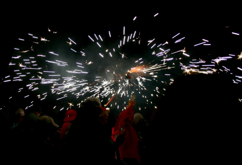 fireworks show in the night sky while people watch