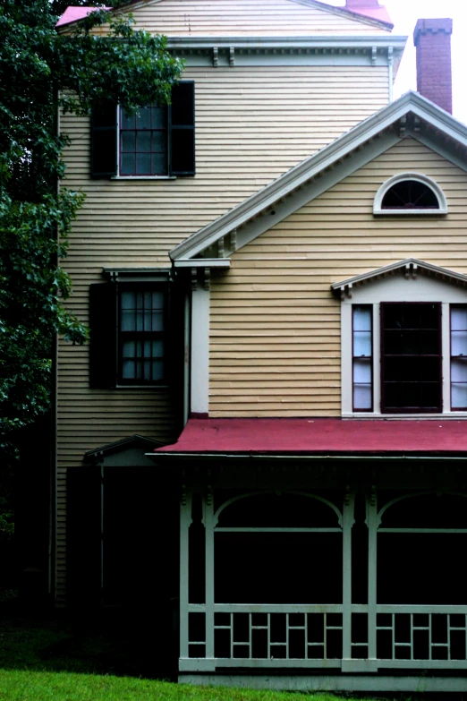 a two story house with a porch and covered gazebo