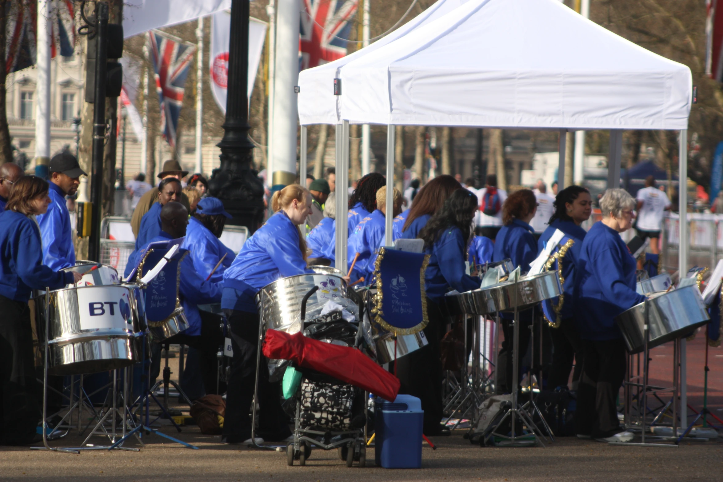 a group of women in blue shirts playing music outside