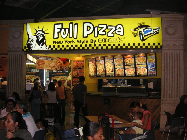 many people are eating pizza at a fast food restaurant