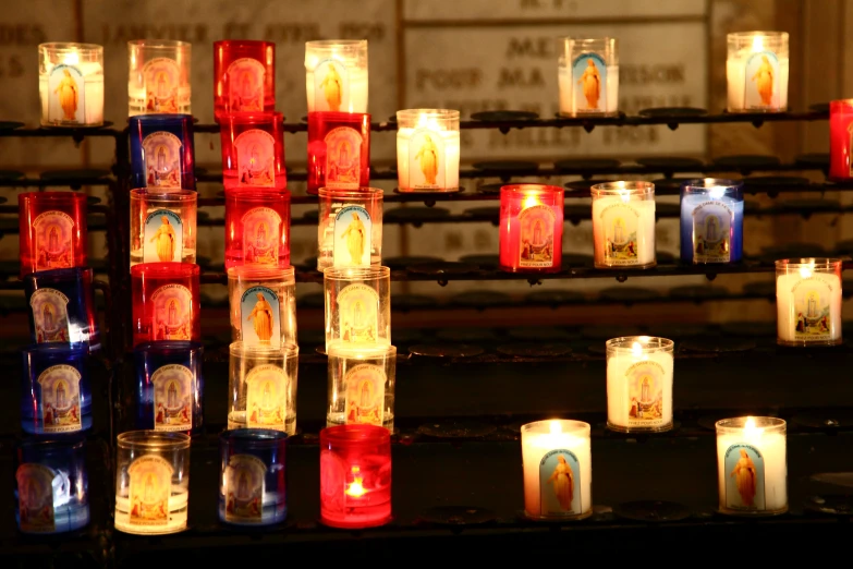 a close up of a couple of lit candles with the virgin of guadalupe