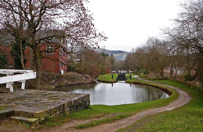 a waterway is going alongside a road by the trees