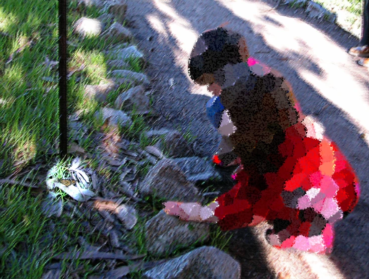 a young child in red is throwing rocks on the ground