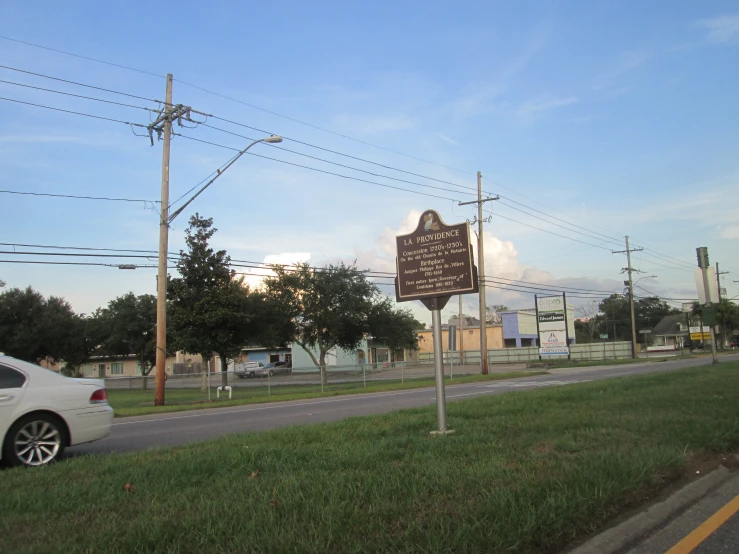 a car parked in front of a sign on a country road