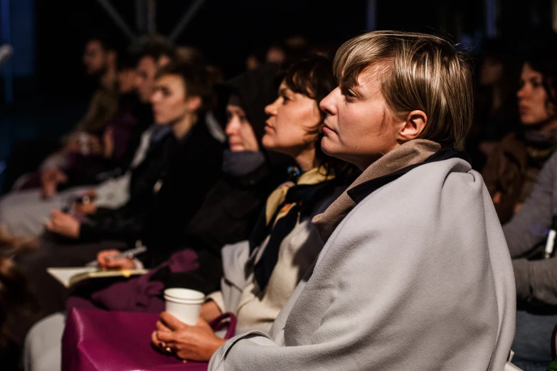 several people sitting in the middle of a row at an event