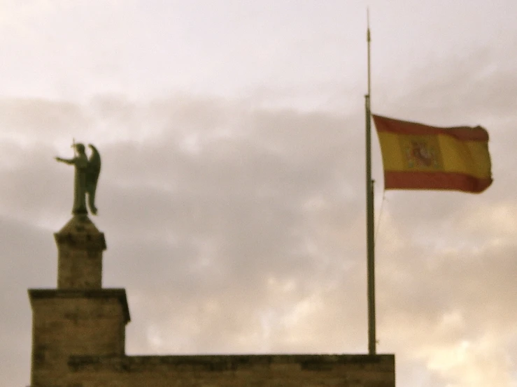 the flag flying in front of a statue and a flag