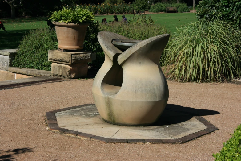 a large sculpture sitting in a courtyard by the grass