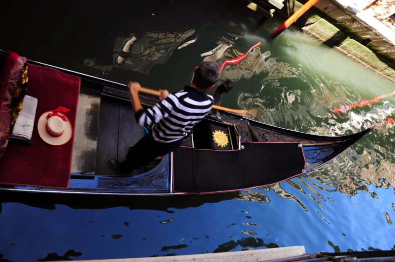 a man sitting in a gondola with two different colored fish floating by