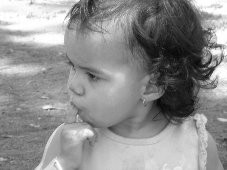 a close - up of a child with her hands to her mouth