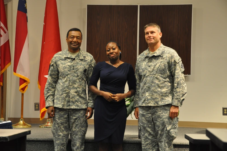 a military couple poses in front of the camera