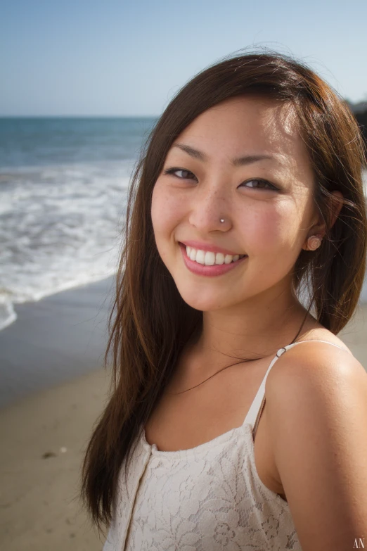 woman wearing pearl necklace smiling at the beach