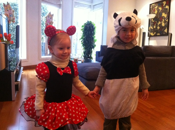 two little girls dressed up in costume in a living room