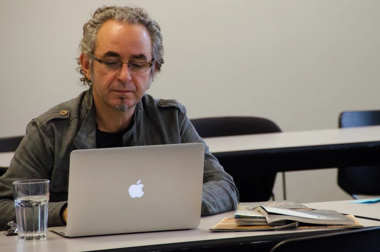 a man sitting in front of a laptop computer