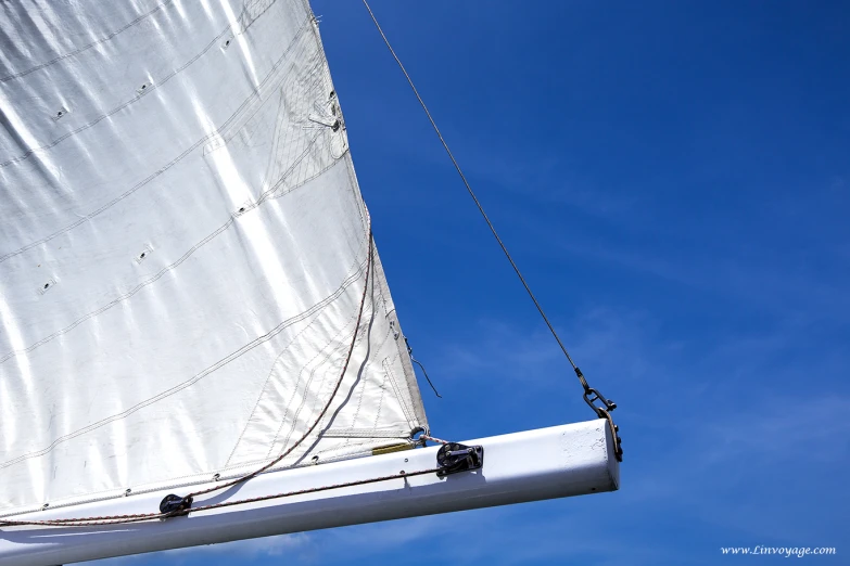 the rig with a white sail against a blue sky