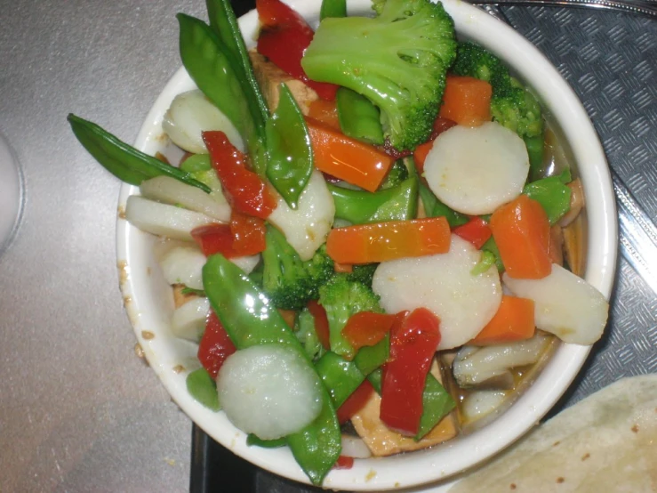 vegetables with carrots, green peppers and onions in a white bowl