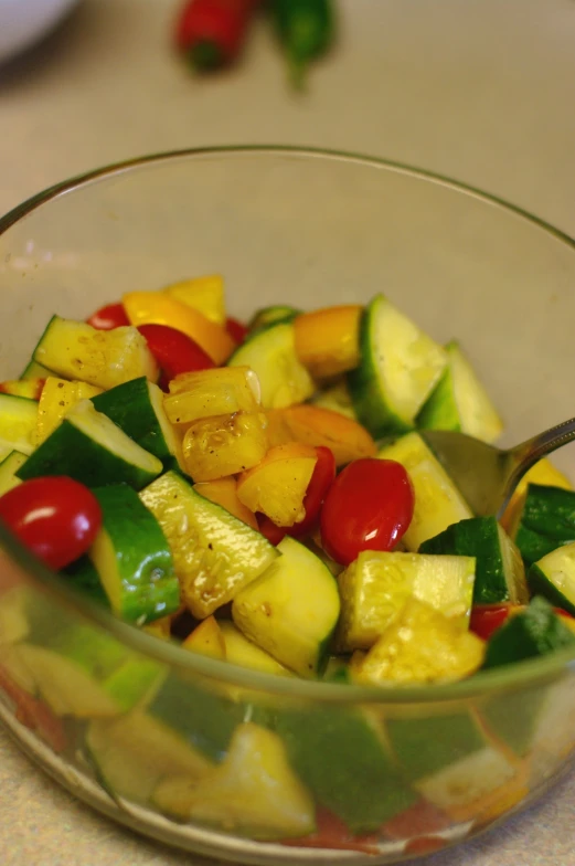 a bowl filled with sliced up veggies next to a fork