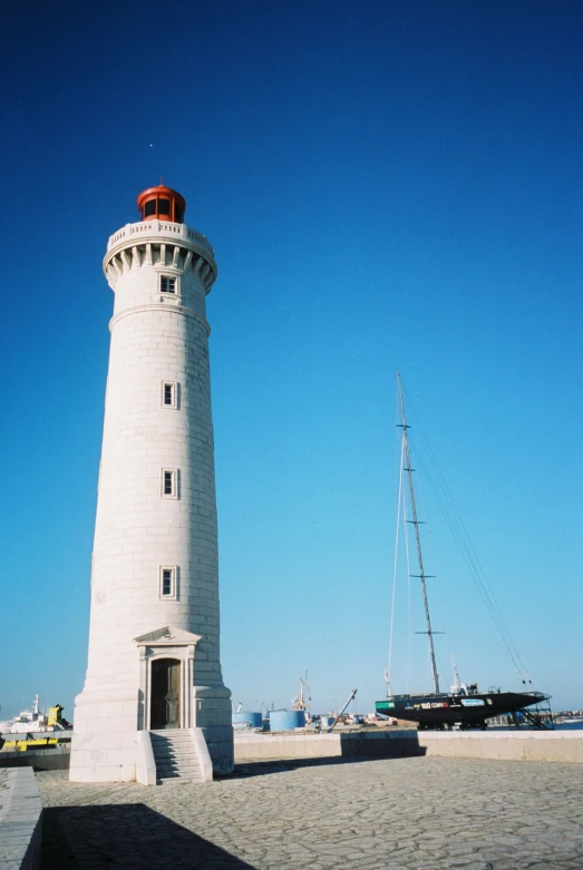 there is a boat docked next to the light house