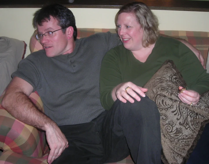 a man and a woman sitting on top of a couch