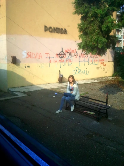 a woman sitting on a bench using a cell phone