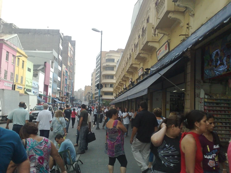 many people walking on the street in front of buildings