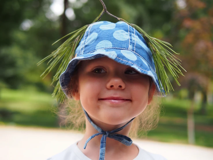 a small child wearing a hat with a tie around the brim