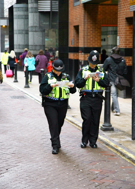 two police officers are walking down the street