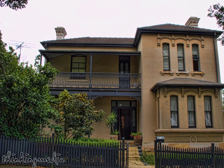 a tan building with a large black gate