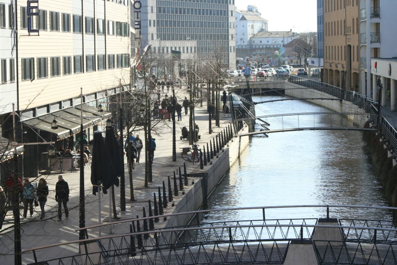 a group of people walking in front of a waterway