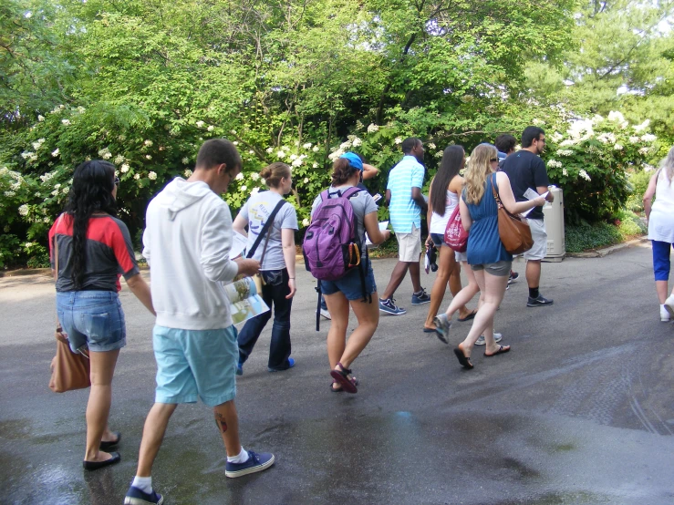 a group of people walking around outside on a rainy day