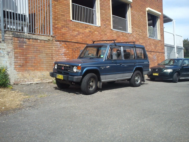 a vehicle parked in front of a building next to a car