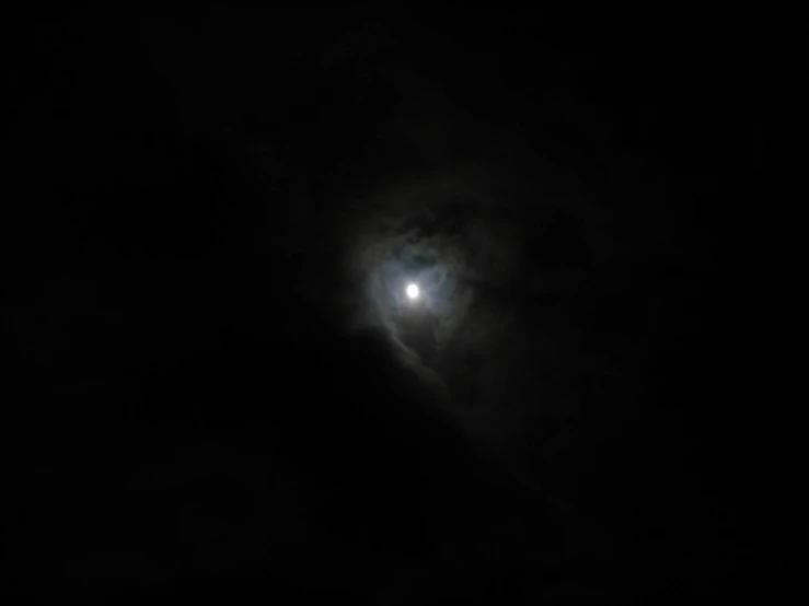 the moon shines brightly in the dark sky