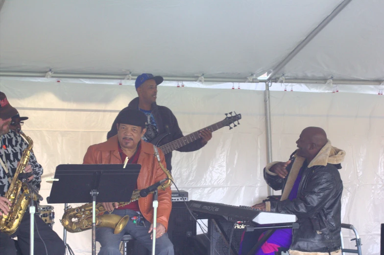 a man that is sitting on a stage with saxophone