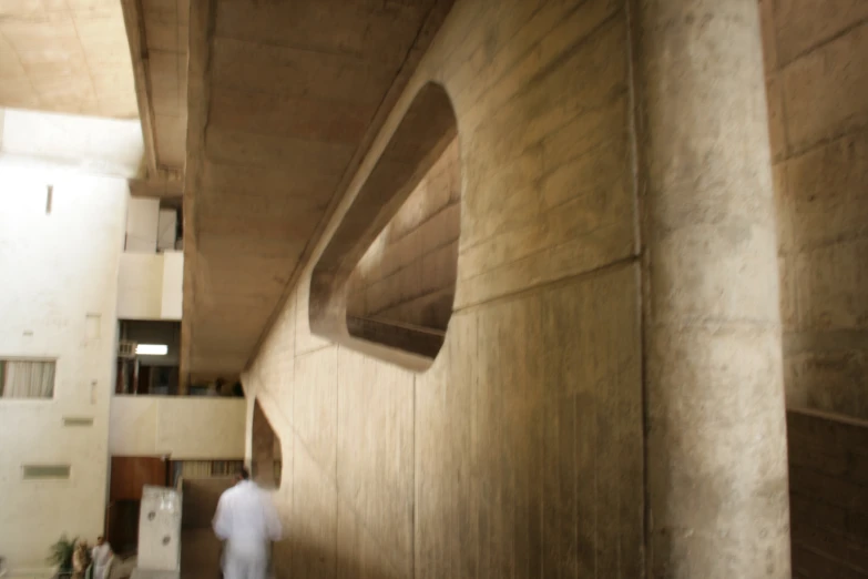 a man in white stands outside of a building