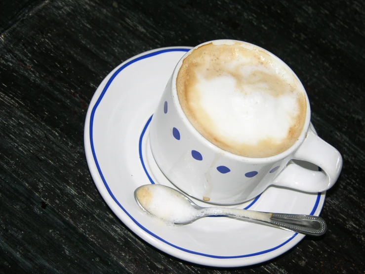 a white plate topped with a cup and a spoon