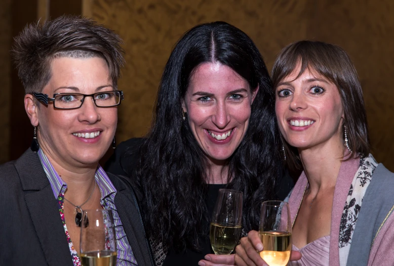 three women pose for a po with champagne