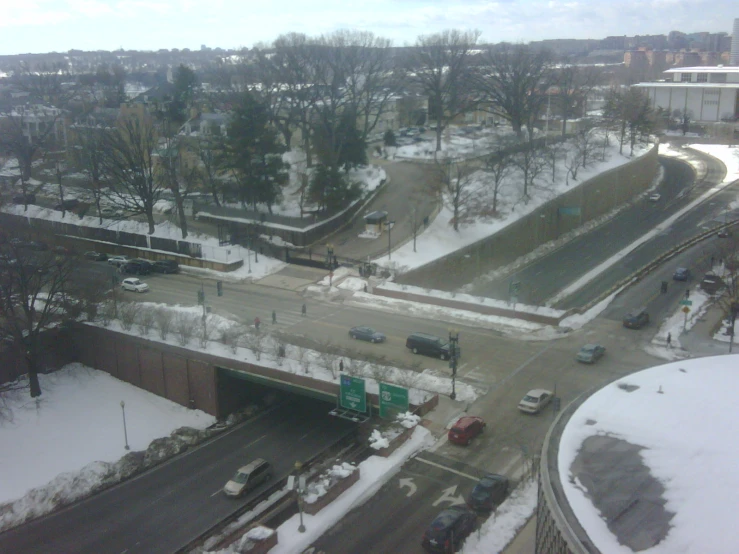 a long snowy street, with several vehicles driving down it