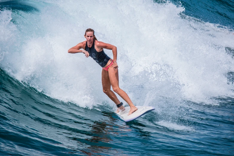 a woman that is on a surfboard in the water