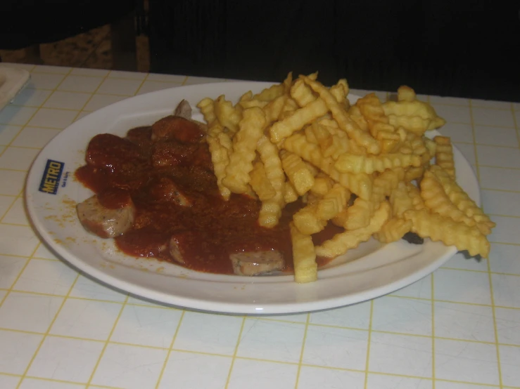 a white plate topped with french fries and meat