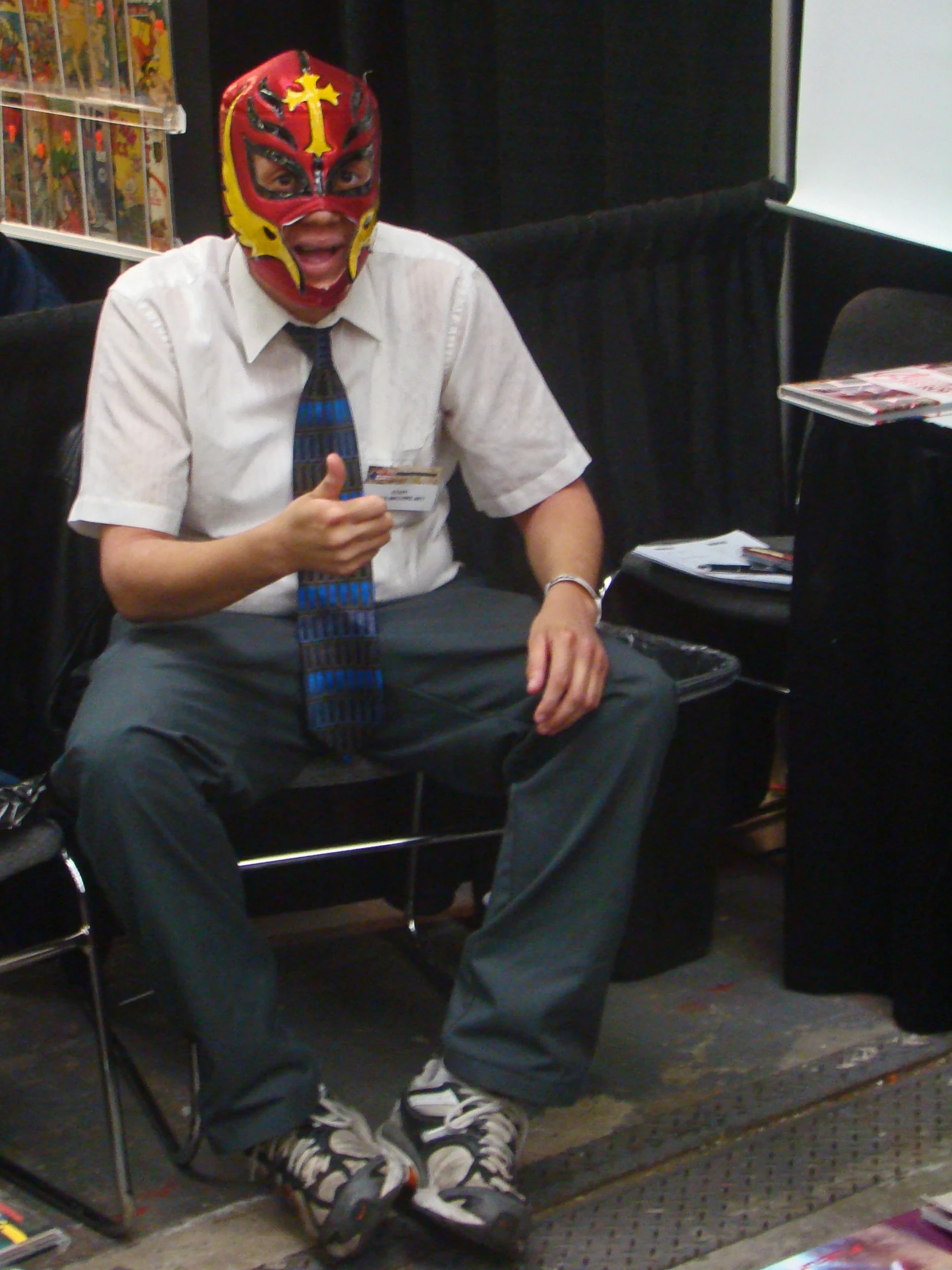 man in business shirt and tie with red mask sitting on chair